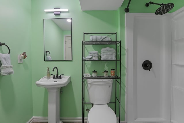 bathroom featuring sink, toilet, and walk in shower