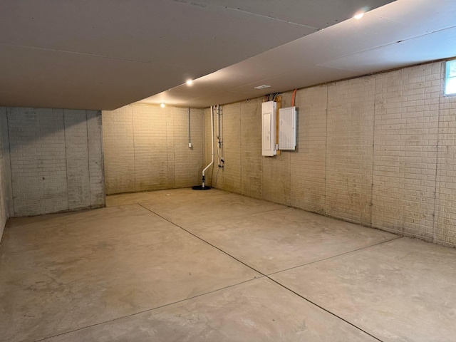 basement with brick wall and electric panel