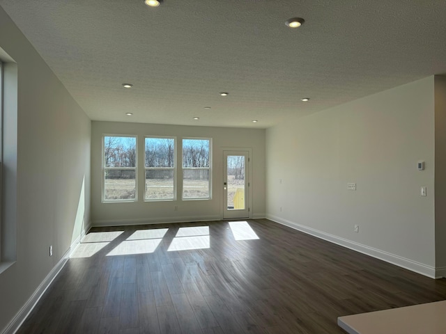 unfurnished room featuring a textured ceiling, dark wood-style flooring, recessed lighting, and baseboards