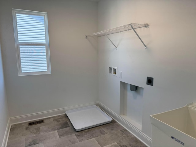 washroom with hookup for a washing machine, hookup for an electric dryer, laundry area, a sink, and baseboards