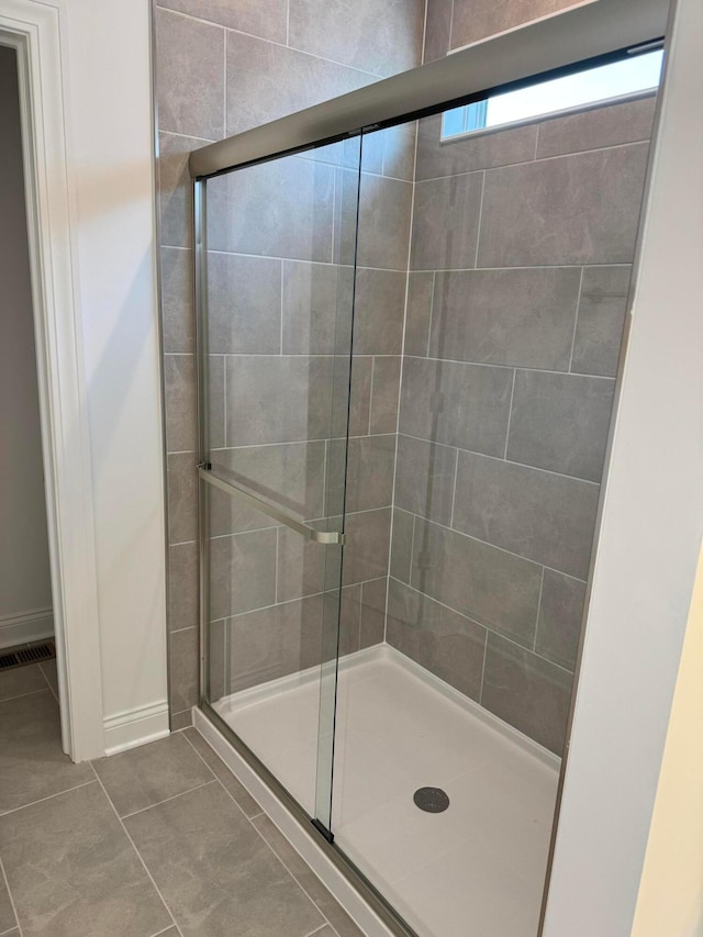 bathroom with a stall shower, visible vents, and tile patterned floors