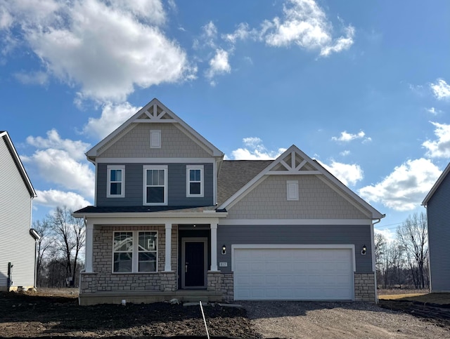 craftsman inspired home with driveway, stone siding, a garage, and covered porch