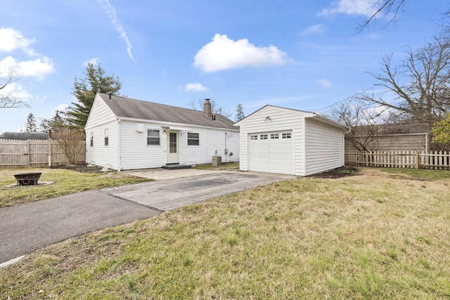 view of front of home featuring an outbuilding, a garage, central AC, and a front lawn