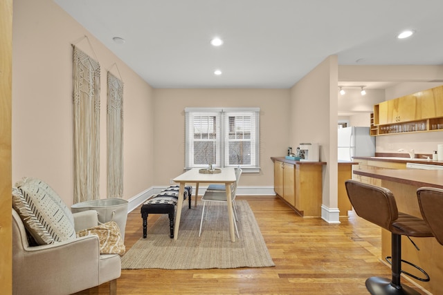 dining room featuring sink and light hardwood / wood-style floors