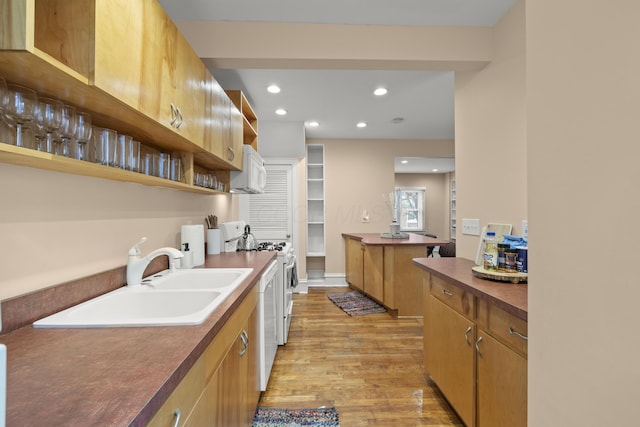 kitchen with a center island, sink, white appliances, and light hardwood / wood-style flooring