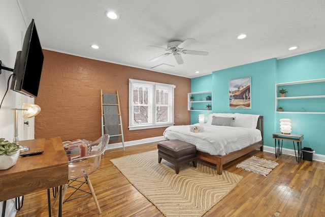 bedroom featuring ceiling fan, hardwood / wood-style floors, and a textured ceiling