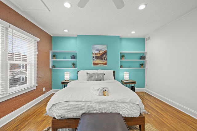 bedroom featuring ceiling fan, hardwood / wood-style floors, and a textured ceiling