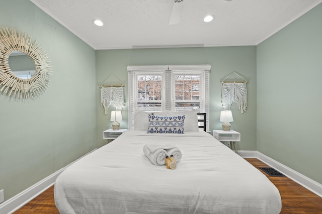 bedroom with ornamental molding, dark hardwood / wood-style floors, ceiling fan, and a textured ceiling