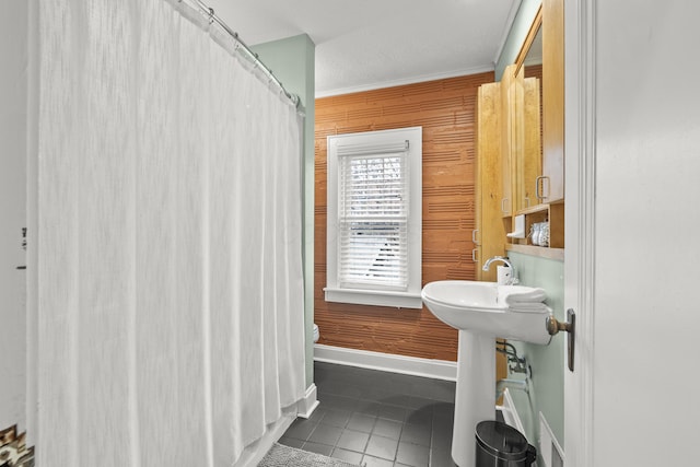 bathroom with toilet, tile patterned floors, and wood walls