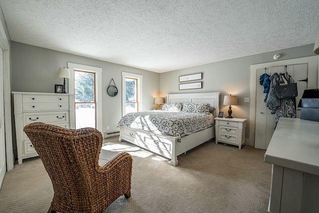 bedroom with access to outside, a baseboard radiator, a textured ceiling, and light carpet