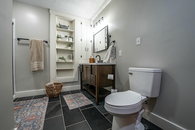 bathroom with tile patterned flooring, built in features, a textured ceiling, toilet, and vanity