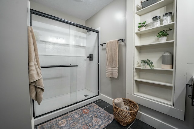 bathroom with a textured ceiling, a shower with door, and tile patterned flooring