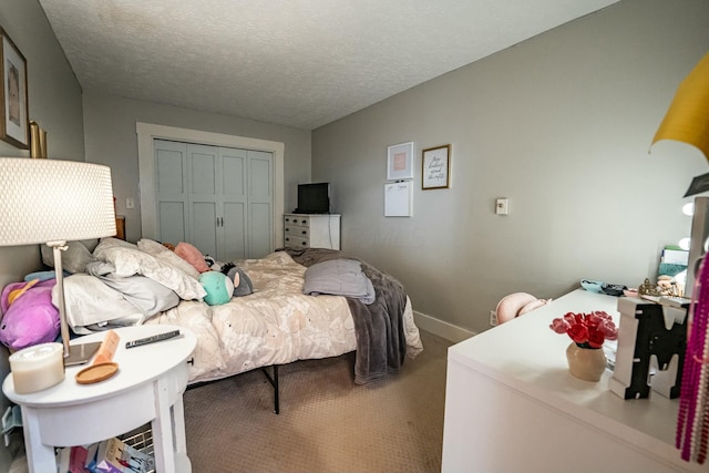 bedroom with carpet floors, a textured ceiling, and a closet