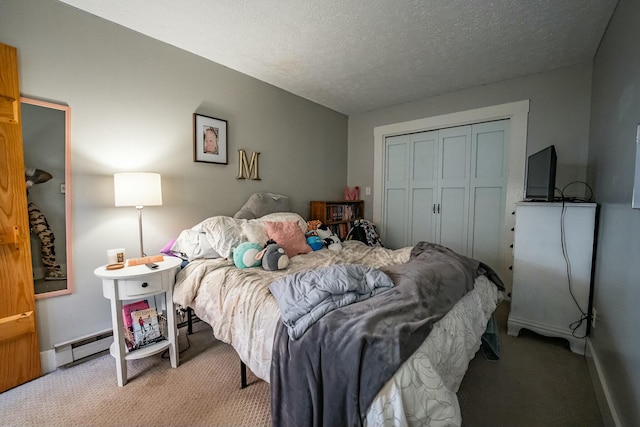 carpeted bedroom featuring baseboard heating, a textured ceiling, and a closet