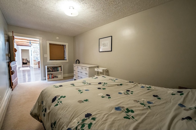 bedroom with light colored carpet and a textured ceiling