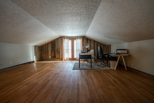 bonus room featuring vaulted ceiling, a textured ceiling, and wood-type flooring