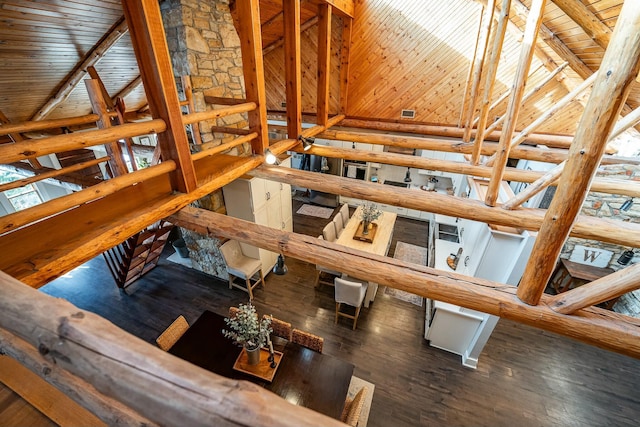 details with wood ceiling, hardwood / wood-style floors, rustic walls, and beamed ceiling