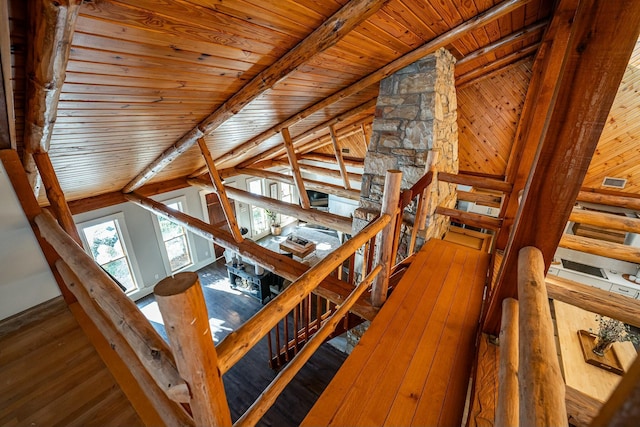 staircase featuring wood-type flooring, wooden ceiling, and lofted ceiling with beams