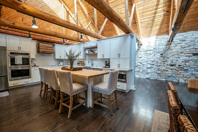 kitchen with backsplash, white cabinetry, wooden ceiling, and butcher block countertops