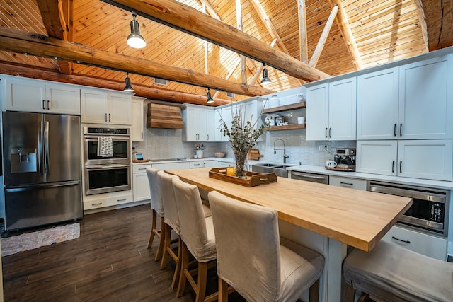 kitchen featuring white cabinetry, wood ceiling, a kitchen island, wood counters, and stainless steel appliances