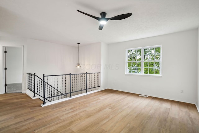 unfurnished room with ceiling fan and hardwood / wood-style floors