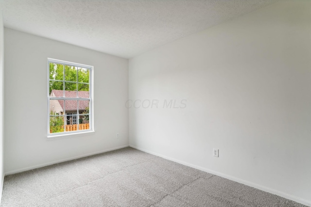 carpeted empty room with a textured ceiling