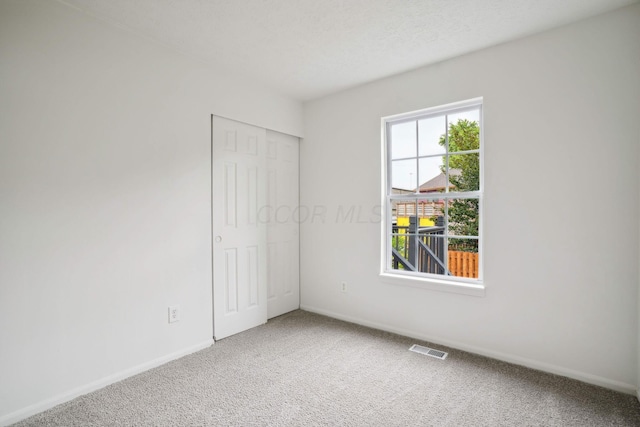 unfurnished bedroom with carpet flooring and a closet