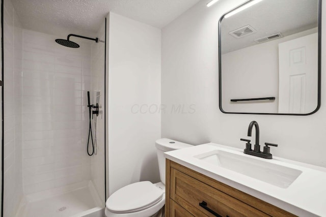 bathroom with vanity, a shower, a textured ceiling, and toilet