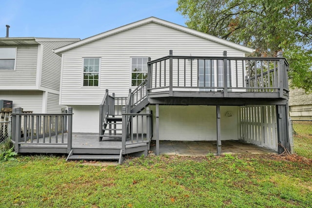 back of property featuring a patio area, a deck, and a lawn