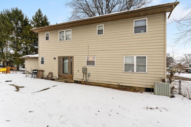 snow covered house featuring central AC