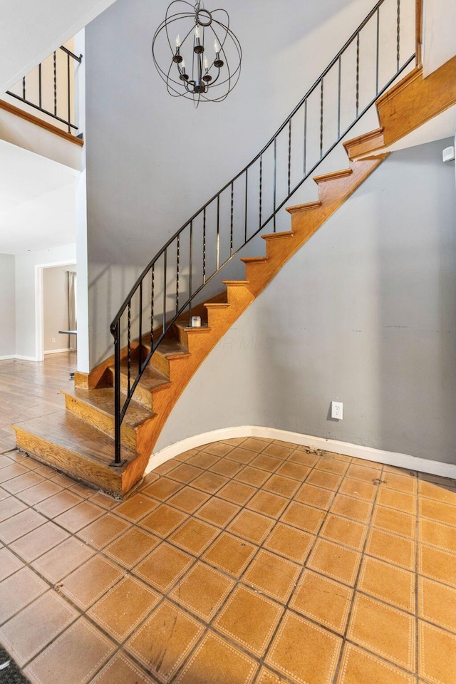 stairway featuring tile patterned flooring and a notable chandelier