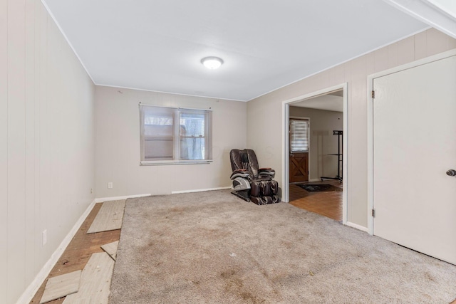 unfurnished room featuring light carpet and wood walls