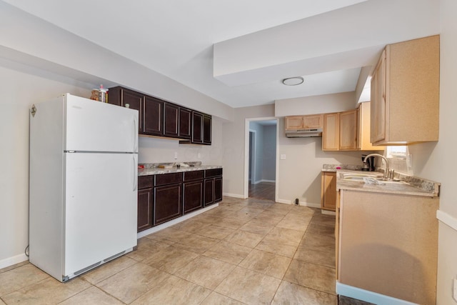 kitchen featuring sink, dark brown cabinets, and white refrigerator