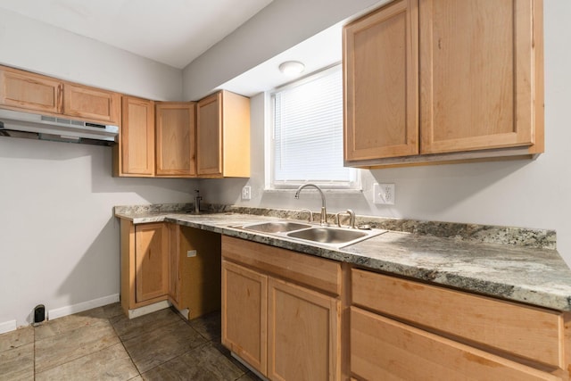 kitchen featuring tile patterned floors, stone countertops, and sink