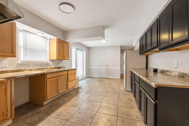 kitchen featuring fridge, sink, and light tile patterned floors