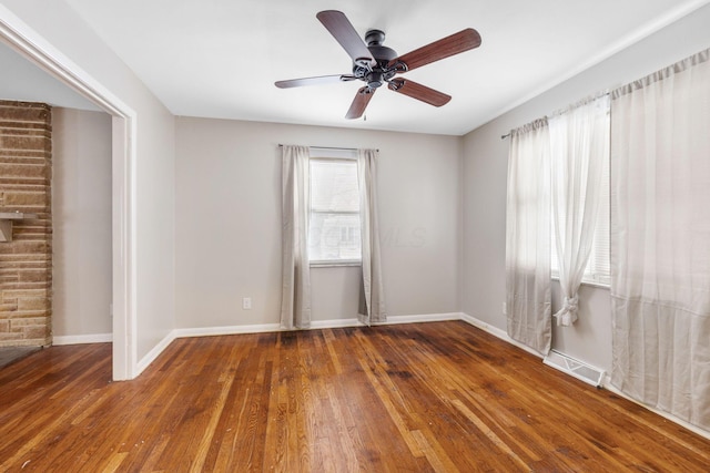 empty room with ceiling fan and dark hardwood / wood-style flooring