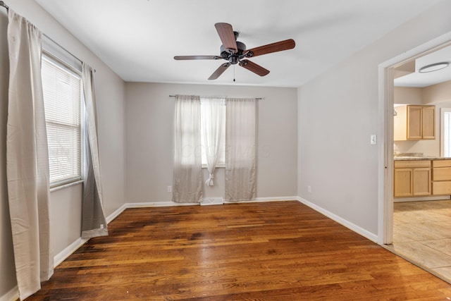 empty room with dark wood-type flooring and ceiling fan