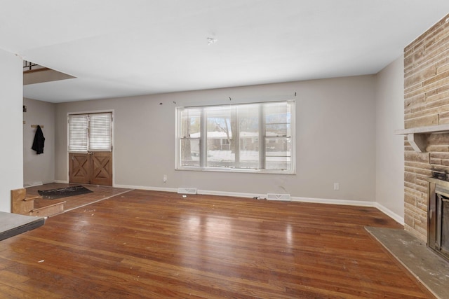 unfurnished living room featuring dark hardwood / wood-style floors and a fireplace