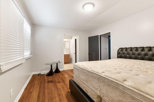 bedroom with ensuite bath and wood-type flooring