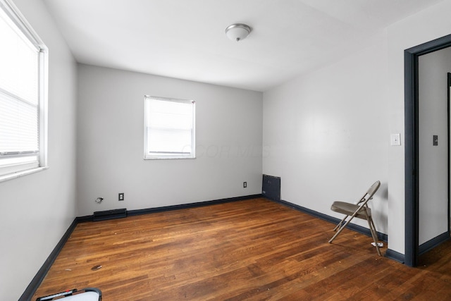 unfurnished room with dark hardwood / wood-style floors and a wealth of natural light