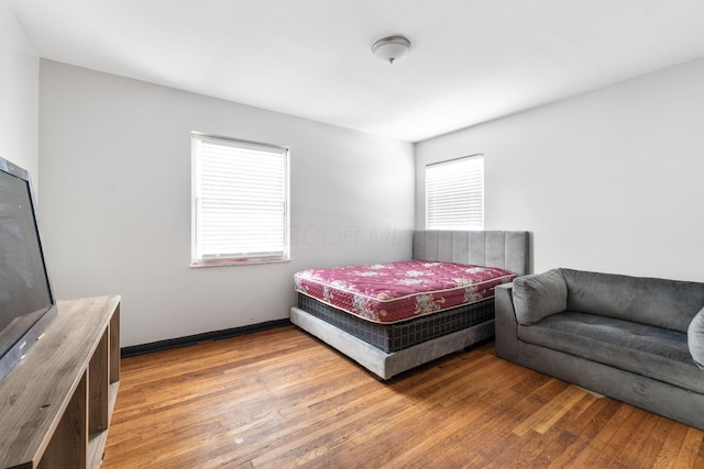 bedroom with hardwood / wood-style flooring and multiple windows