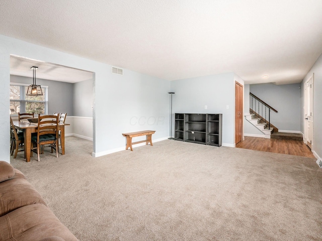 carpeted living room featuring a textured ceiling