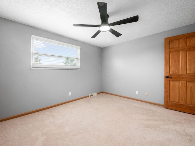 unfurnished room with ceiling fan, light colored carpet, and a textured ceiling