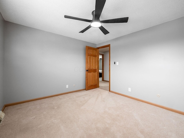 carpeted empty room featuring ceiling fan and a textured ceiling