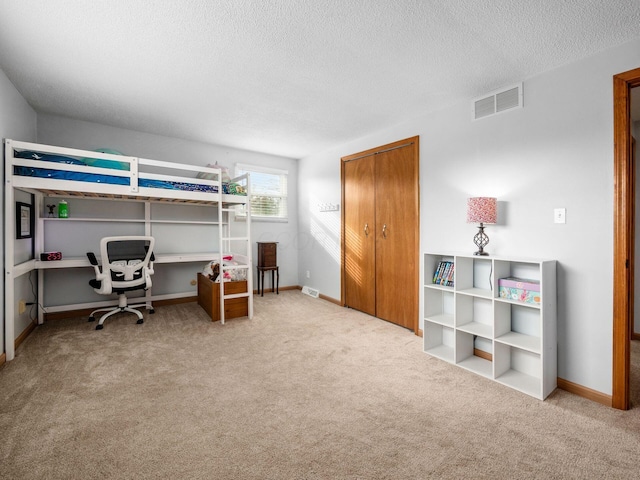 bedroom with light carpet and a textured ceiling