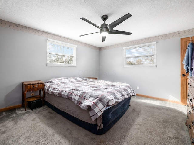 carpeted bedroom featuring multiple windows, ceiling fan, and a textured ceiling