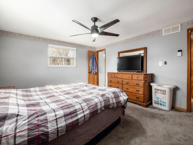 bedroom featuring ceiling fan, a textured ceiling, and carpet flooring