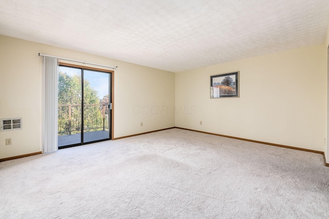 carpeted spare room featuring a textured ceiling