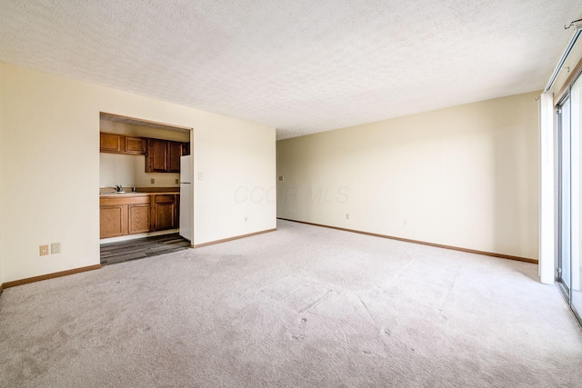 interior space featuring light carpet, a textured ceiling, and sink