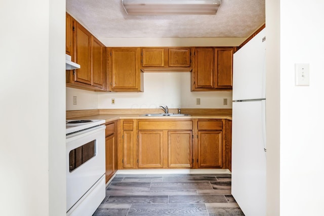 kitchen with sink, white appliances, and a textured ceiling